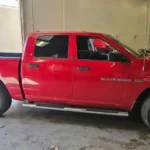 Side view of a red 2012 Dodge Ram 1500 at T Autocare Takedown in Broken Arrow for a pre-purchase vehicle inspection